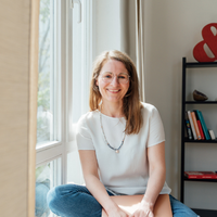 Katja Lippner, Grafikerin, sitz am Fenster und lächelt